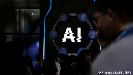 Visitors stand near a sign of artificial intelligence at a trade fair