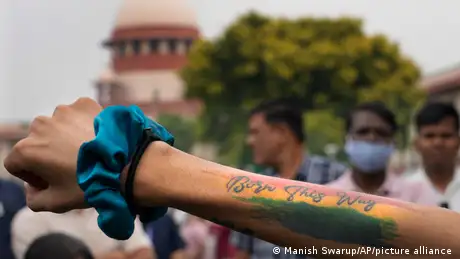 A person displays a tattoo on their arm which reads Born this way at a demonstration in New Delhi